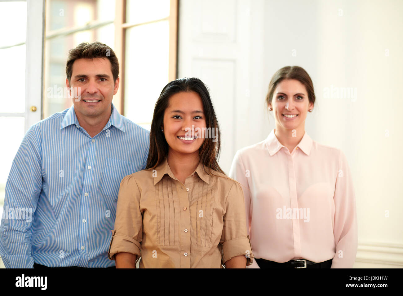 Portrait of man and woman group smiling at you while standing on office ...