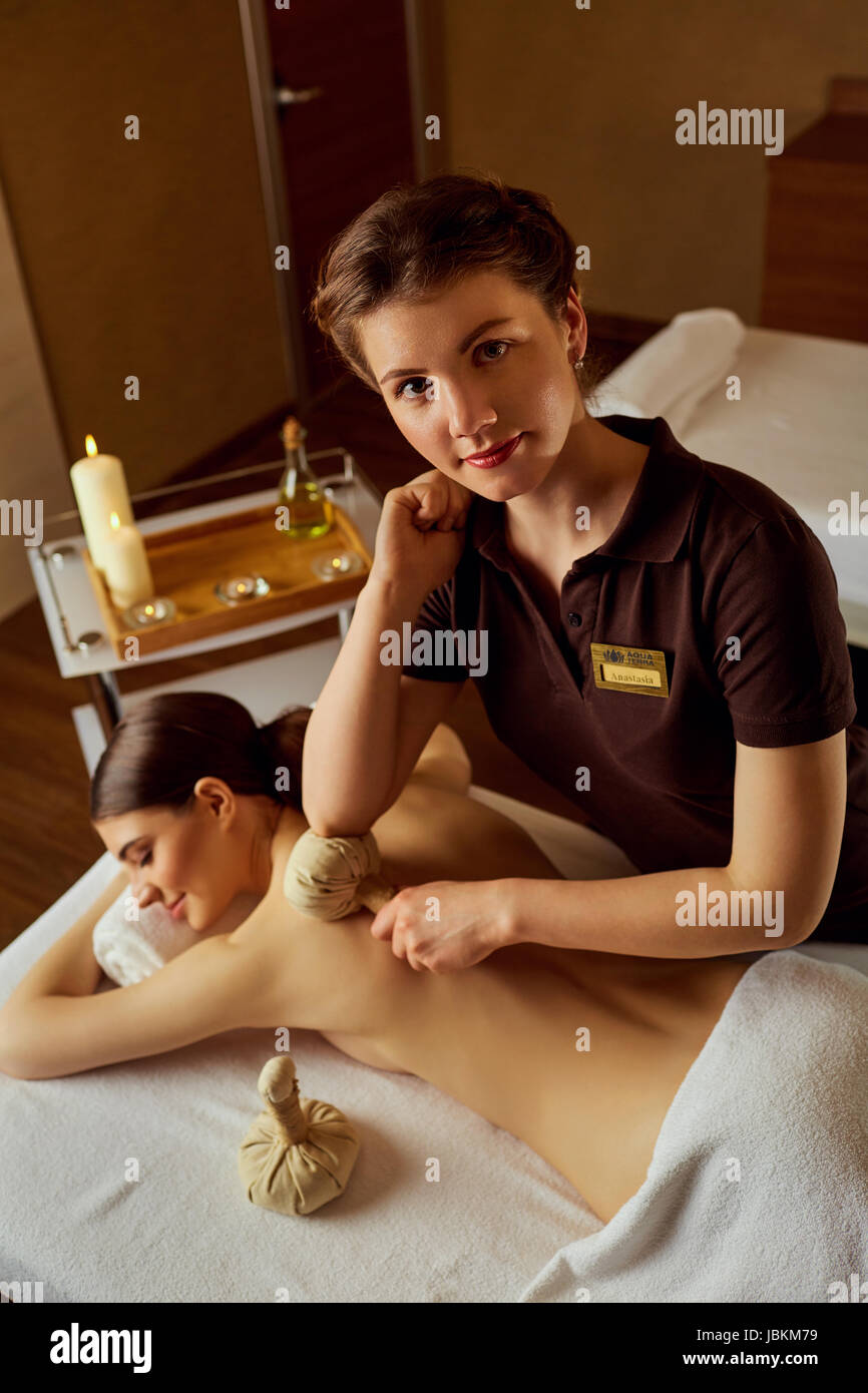 Masseur girl doing massage to woman in spa salon. Stock Photo