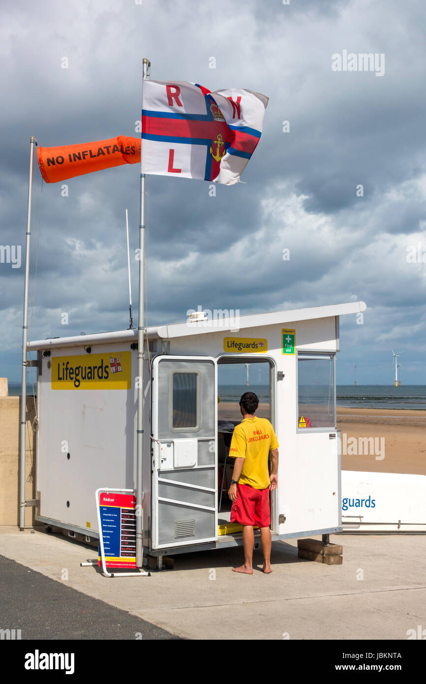 Beach Lifeguard Station, flying an orange windsock marked No Inflatables because of danger to them in a strong offshore wind Stock Photo