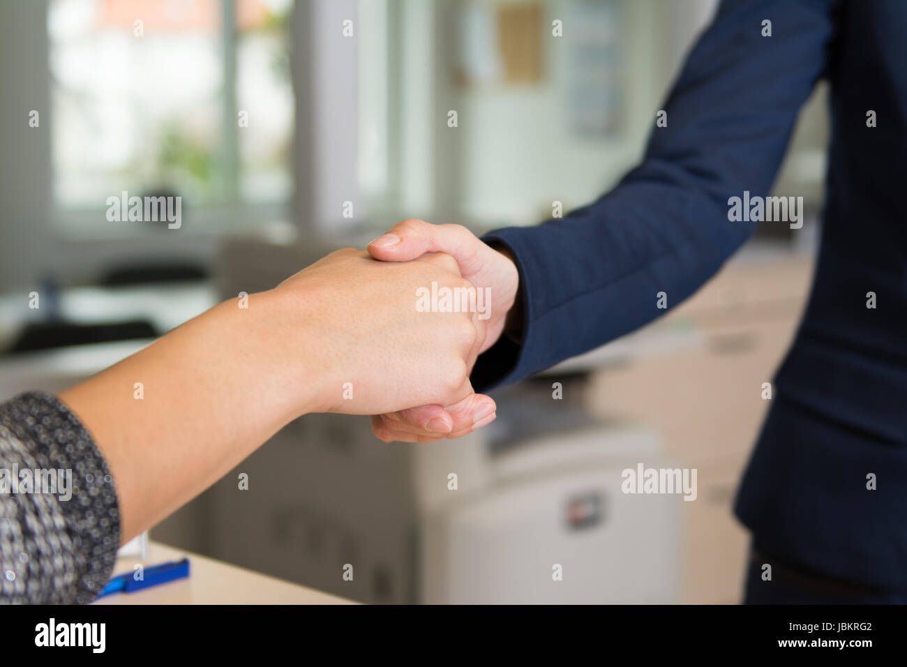 Zwei Frauen begrüßen sich durch Händedruck im Büro. Stock Photo