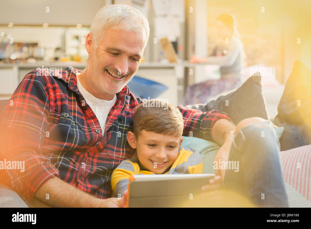 Father and son bonding, sharing digital tablet on sofa Stock Photo