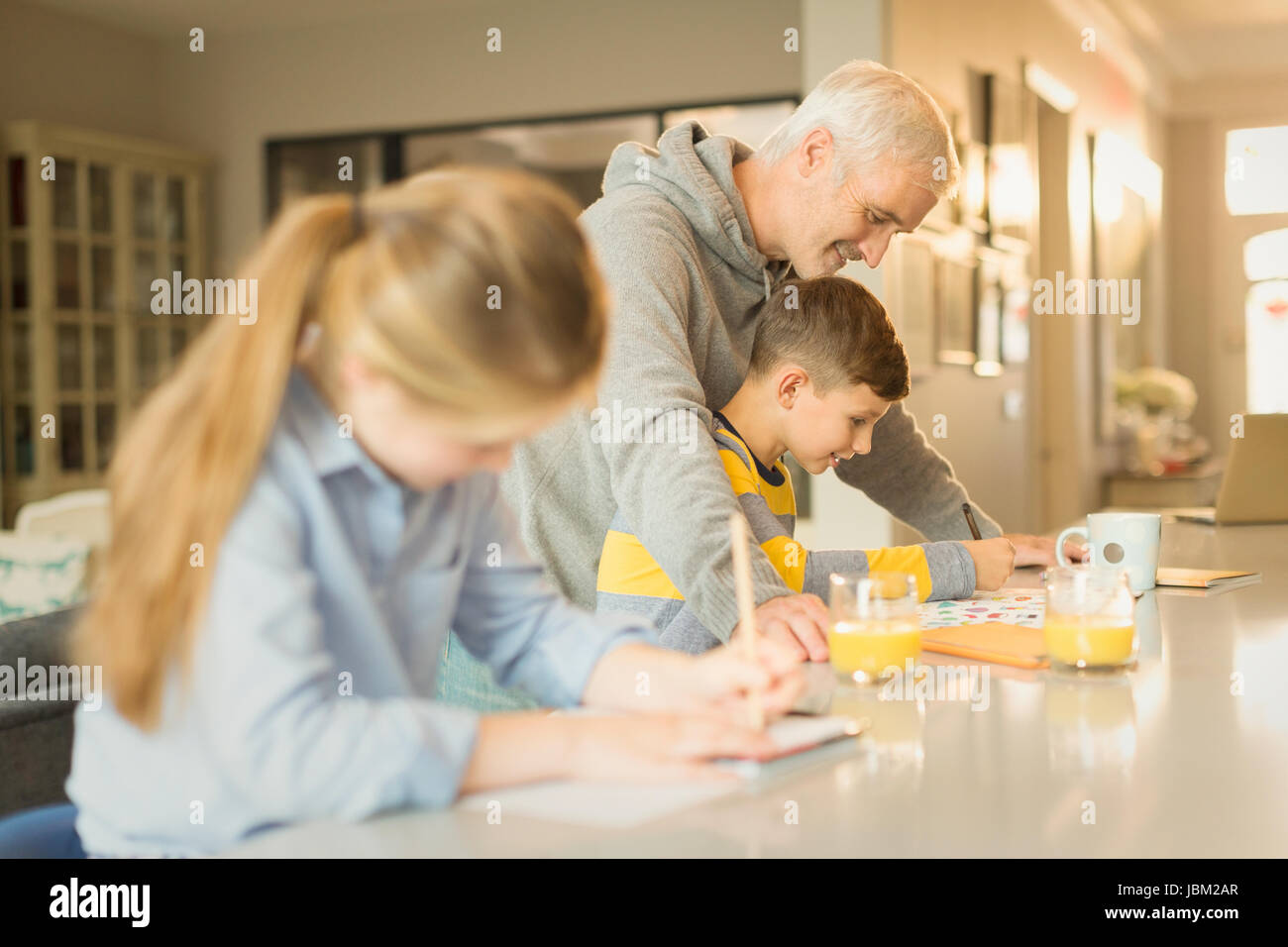 Father helping son with homework at counter Stock Photo - Alamy