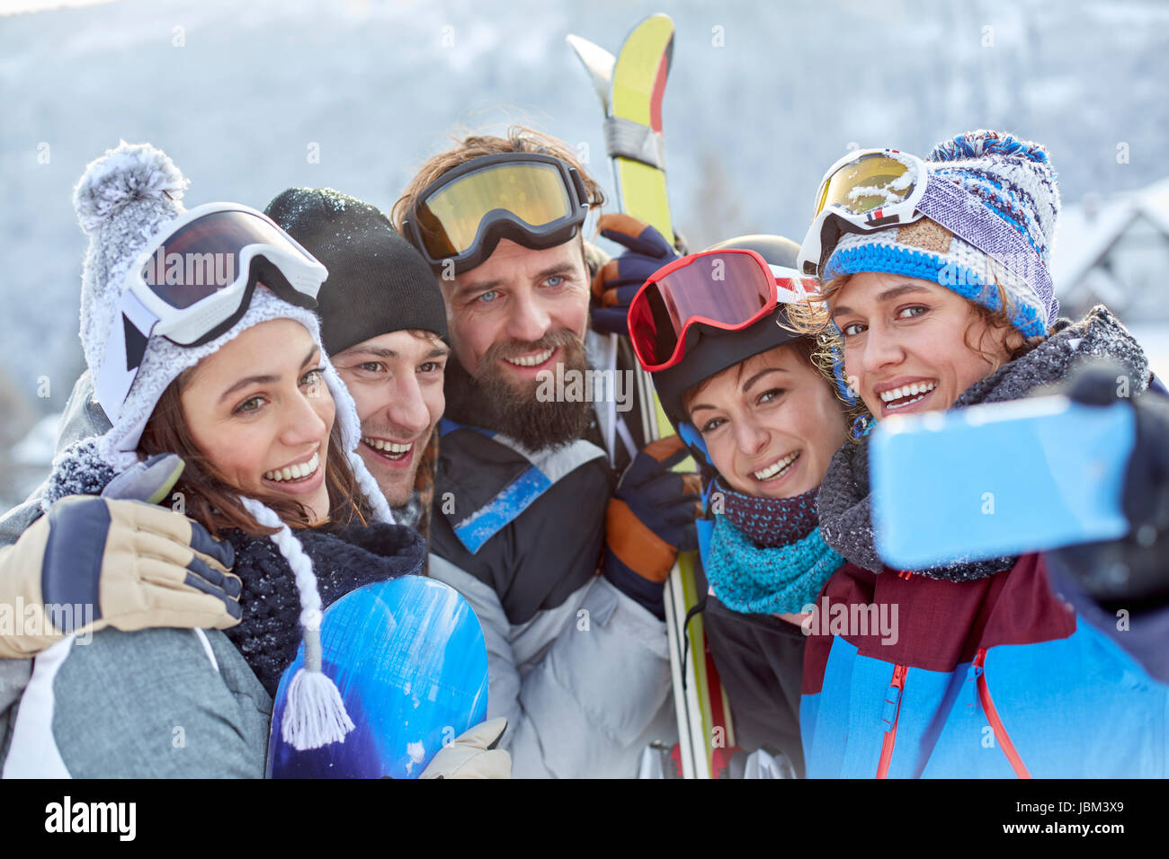 Smiling skier friends taking selfie with camera phone Stock Photo