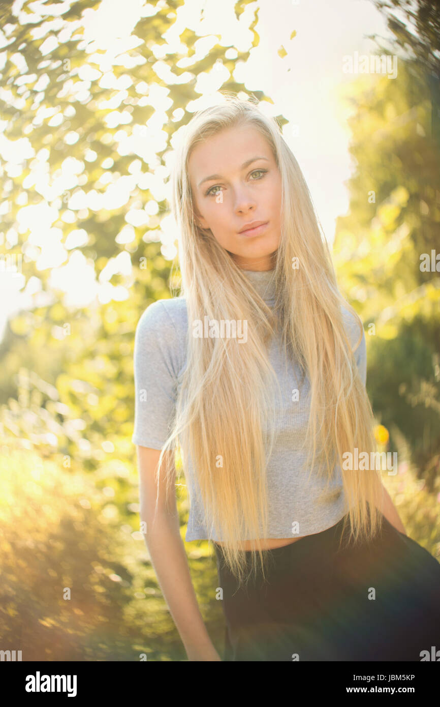 Portrait serious, beautiful blonde teenage girl outdoors Stock Photo