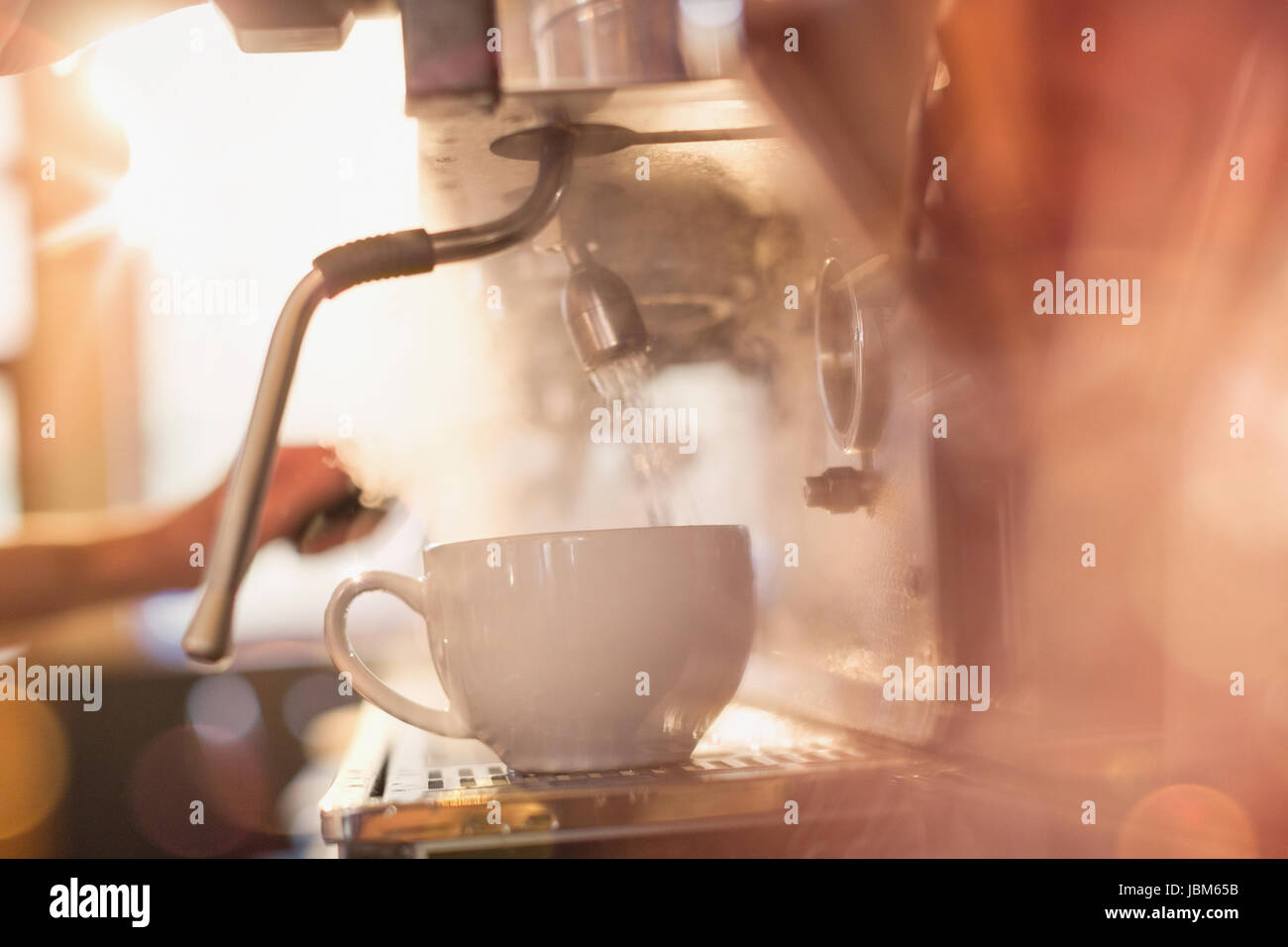 Close up espresso machine filling coffee cup with hot water Stock Photo