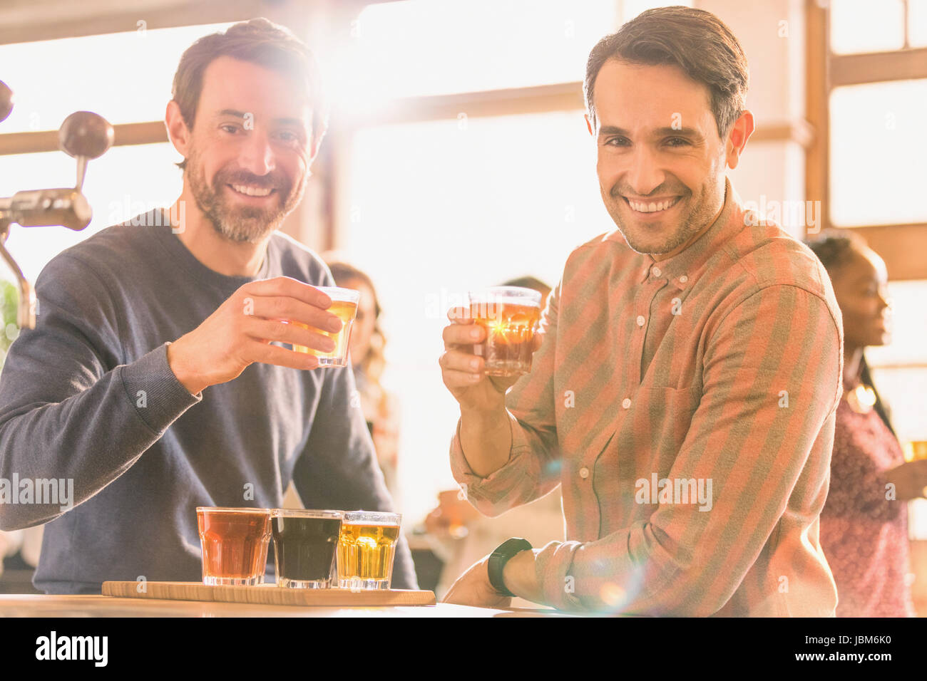 Portrait smiling men friends sampling beer at microbrewery bar Stock Photo