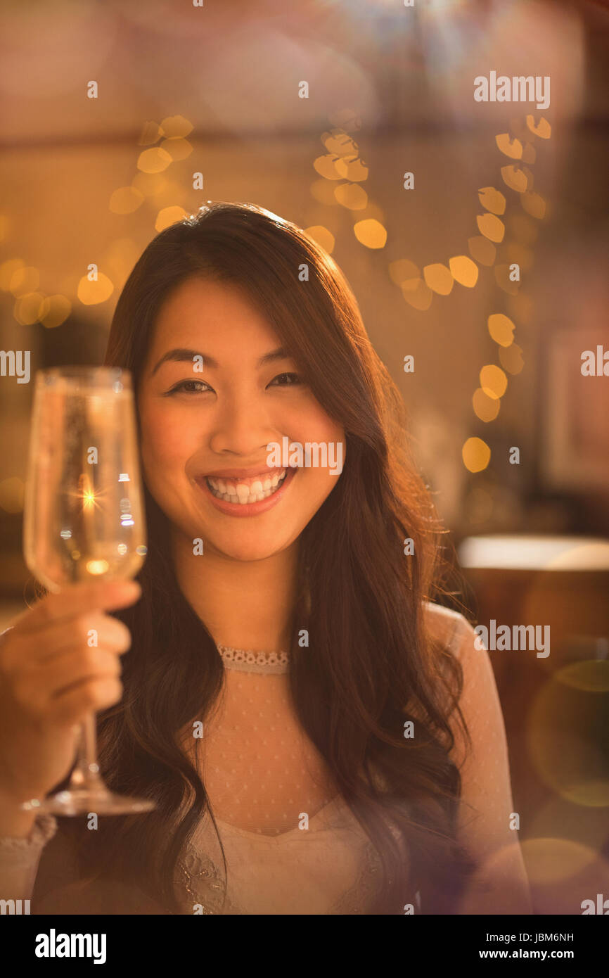 Portrait smiling Chinese woman toasting champagne flute Stock Photo