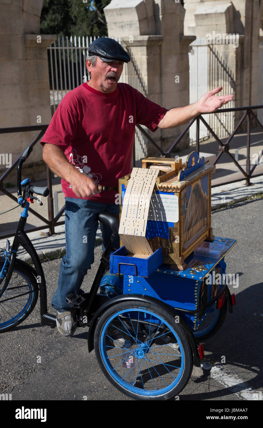 Street entertainer with hand cranked book music barrel organ, Arles, France Stock Photo