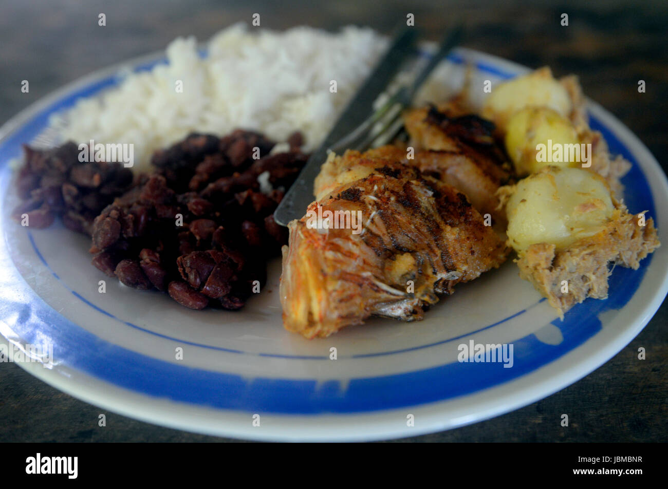 A lionfish is served up with rice, beans and potatoes Stock Photo Alamy