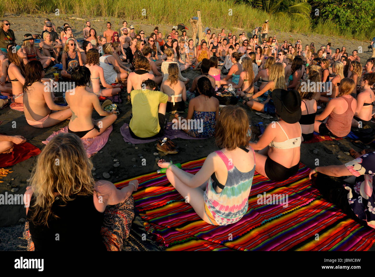 A group meditates on the beach at the 2015 Envision Festival, a transformational festival on Costa Rica's Pacific Coast. Stock Photo