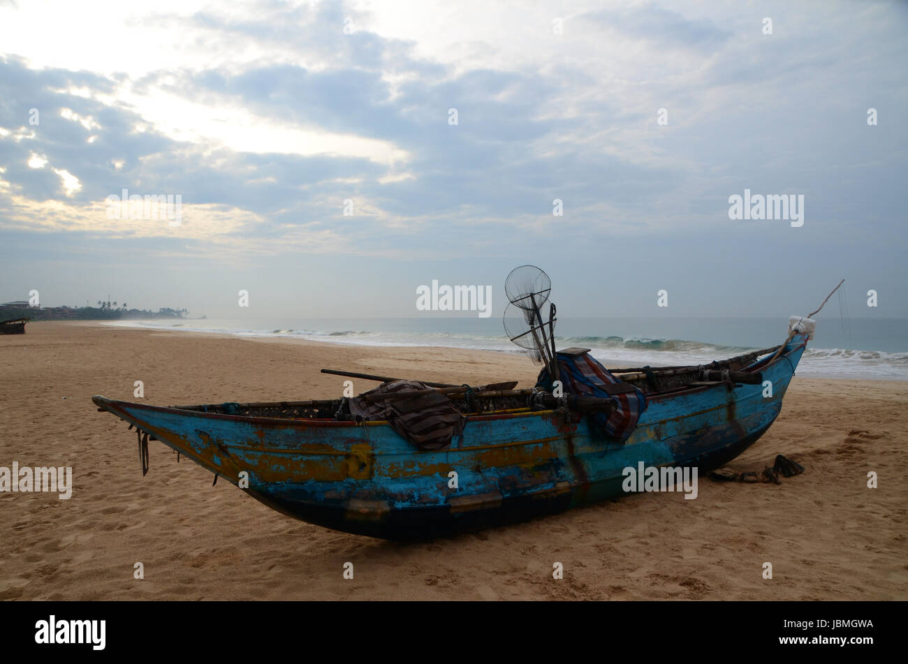 Altes blaues traditionelles Fischerboot mit netzen und KŠschern an einem menschenleeren Strand von Sri Lanka Stock Photo