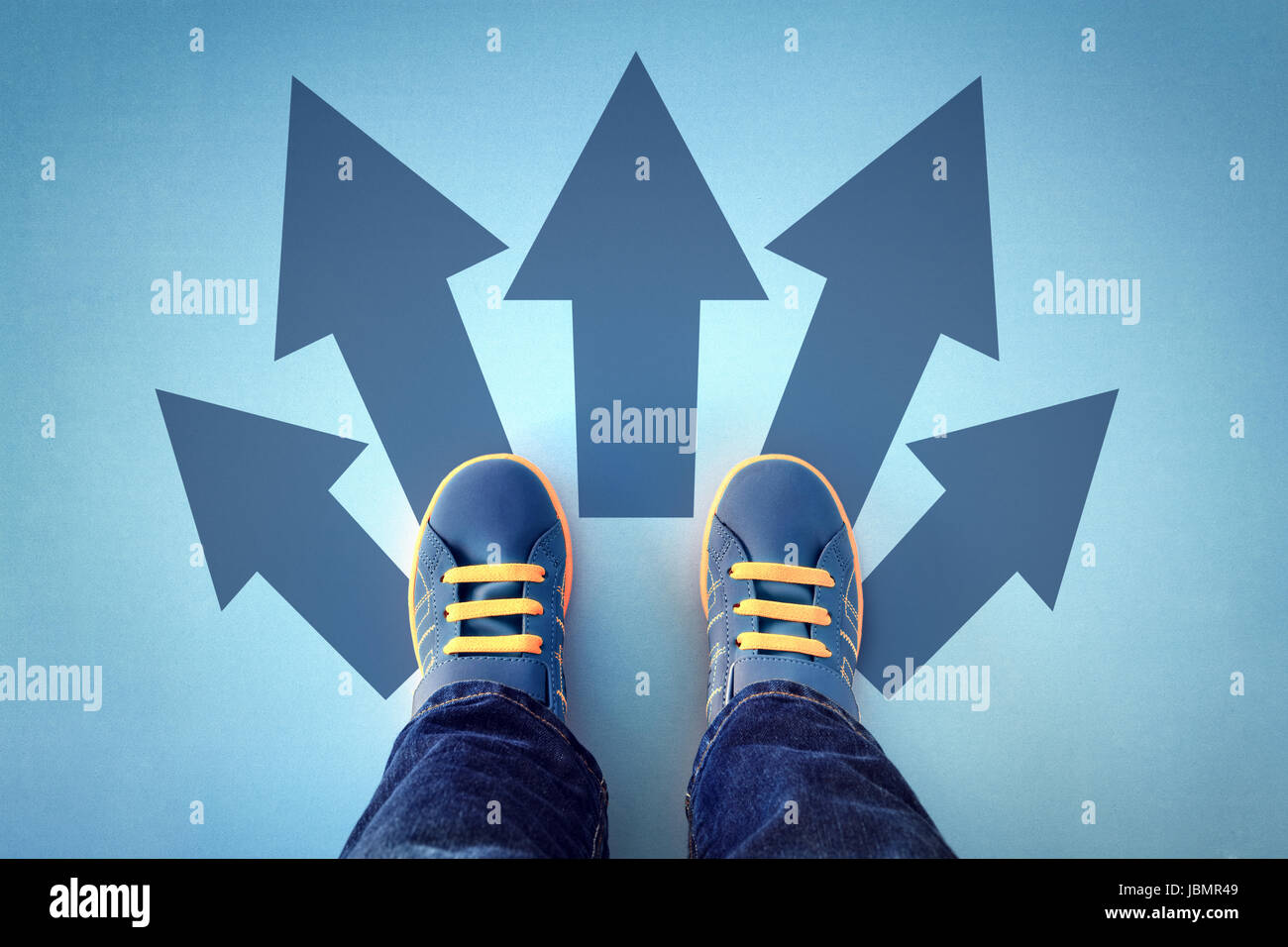Taking decisions for the future child standing with many direction arrow choices, left, right or move forward Stock Photo