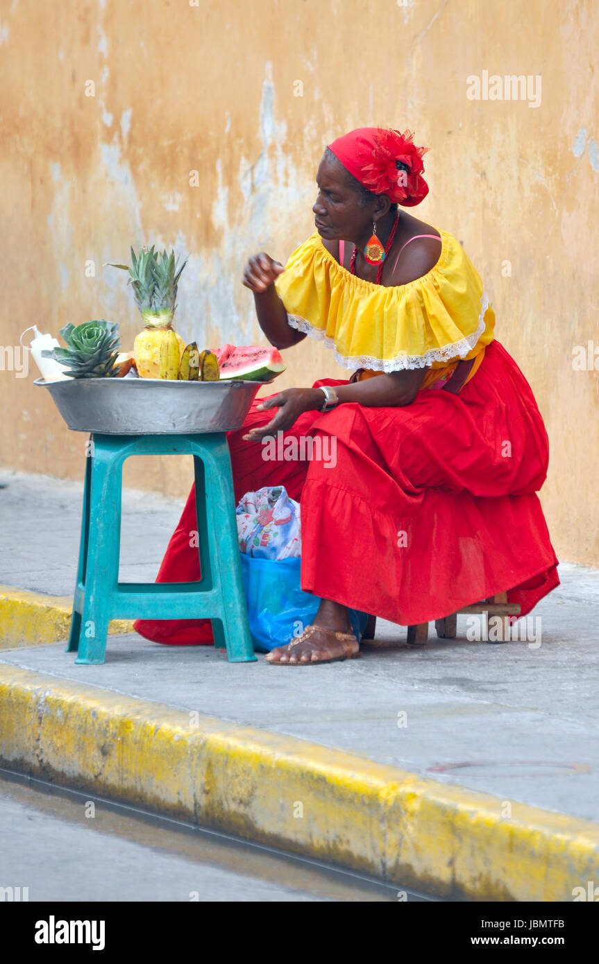 CARTAGENA, MAY 13: Palenquera woman with typical dress sells fruit on the Street on May 13, 2010 in Cartagena, Colombia. Palenqueras are a unique african ethnic group in the north of South America Stock Photo