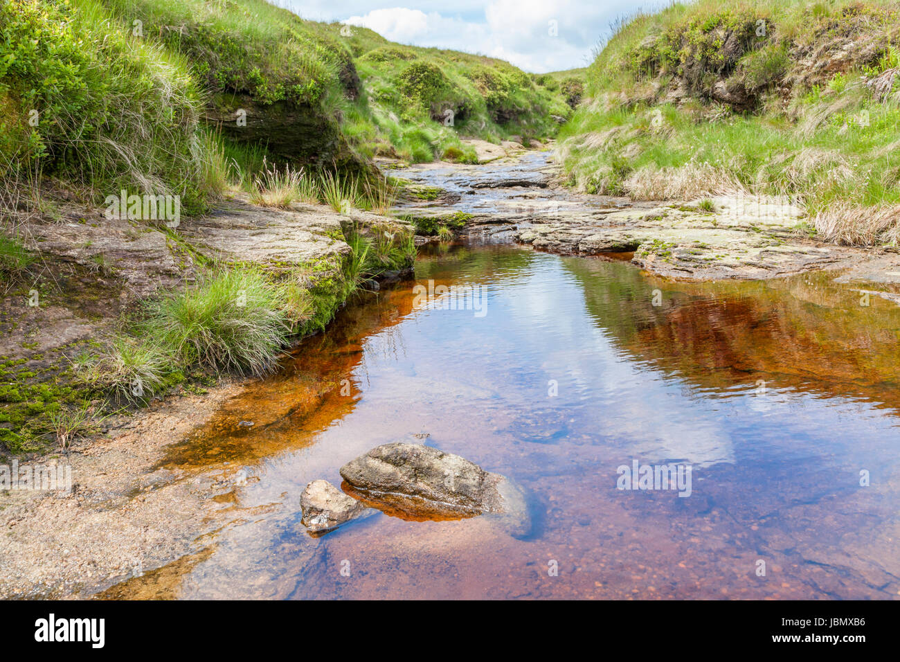 Peat-coloured stream on peat bog moorland, Kinder Scout, Derbyshire, Peak District, England, UK Stock Photo