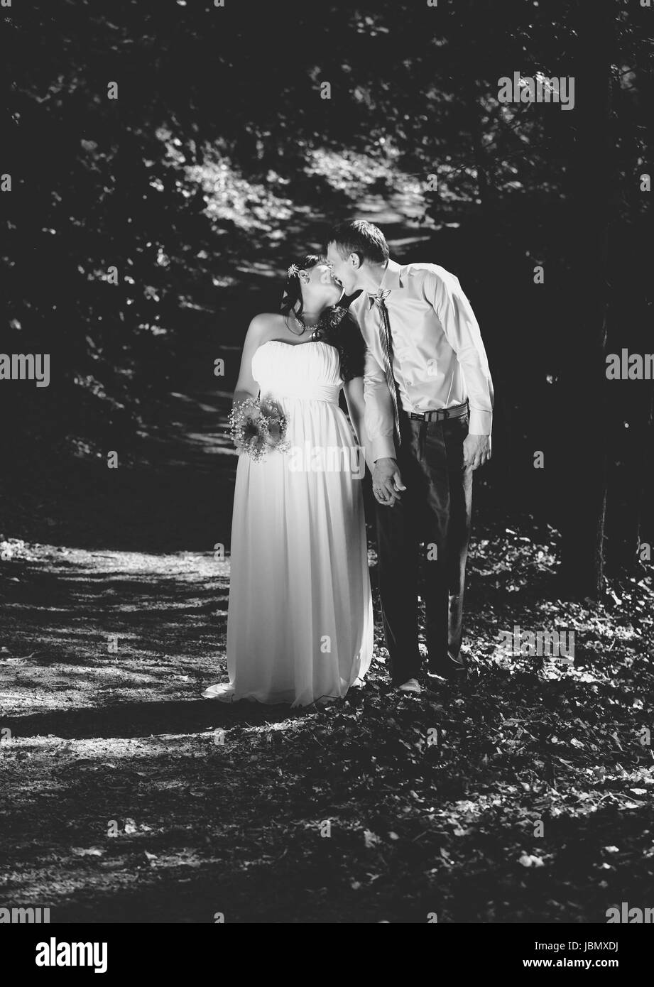 Black and white photo of newly married couple kissing at park Stock ...