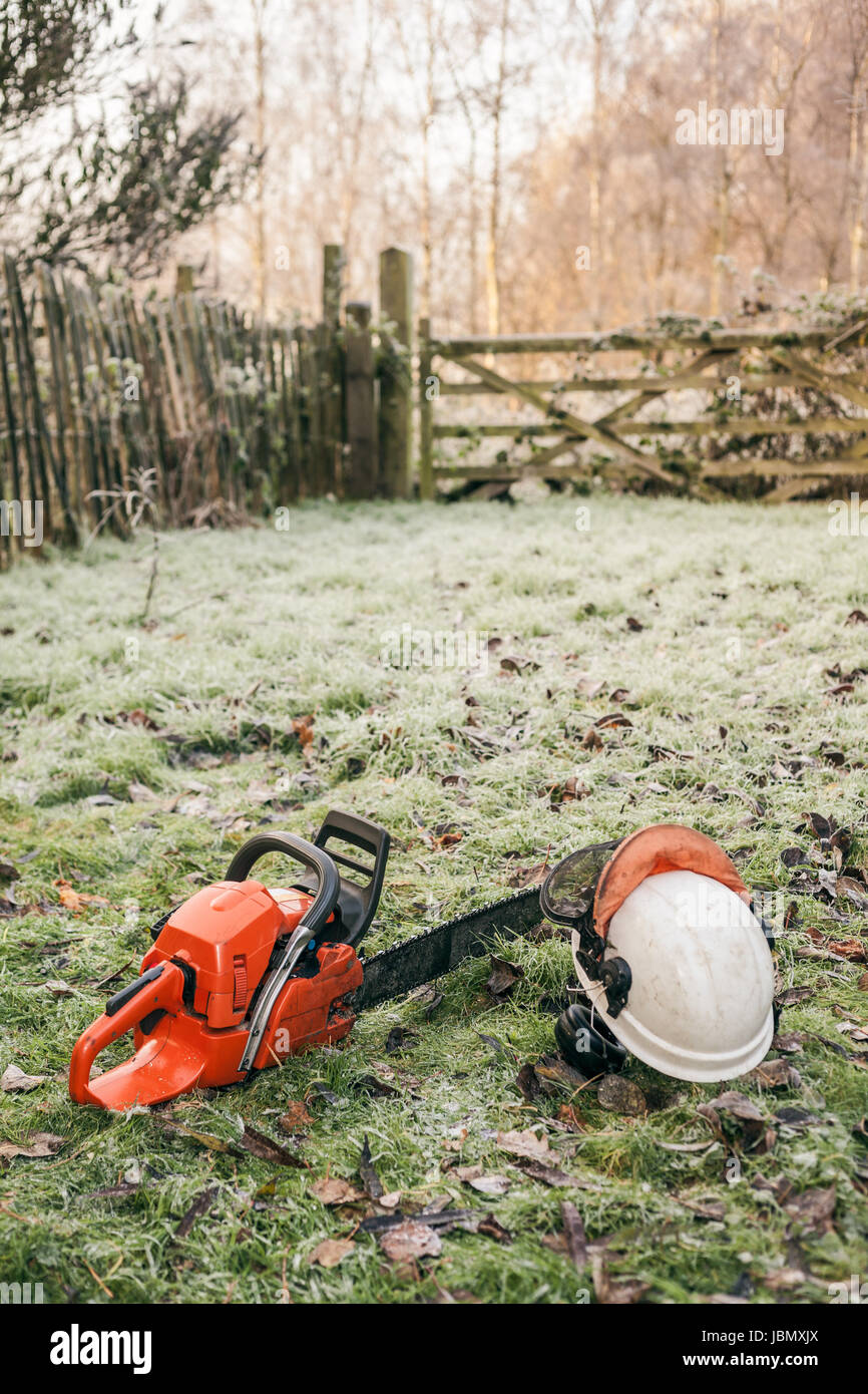 Chainsaw and helmet lying in the garden Stock Photo - Alamy
