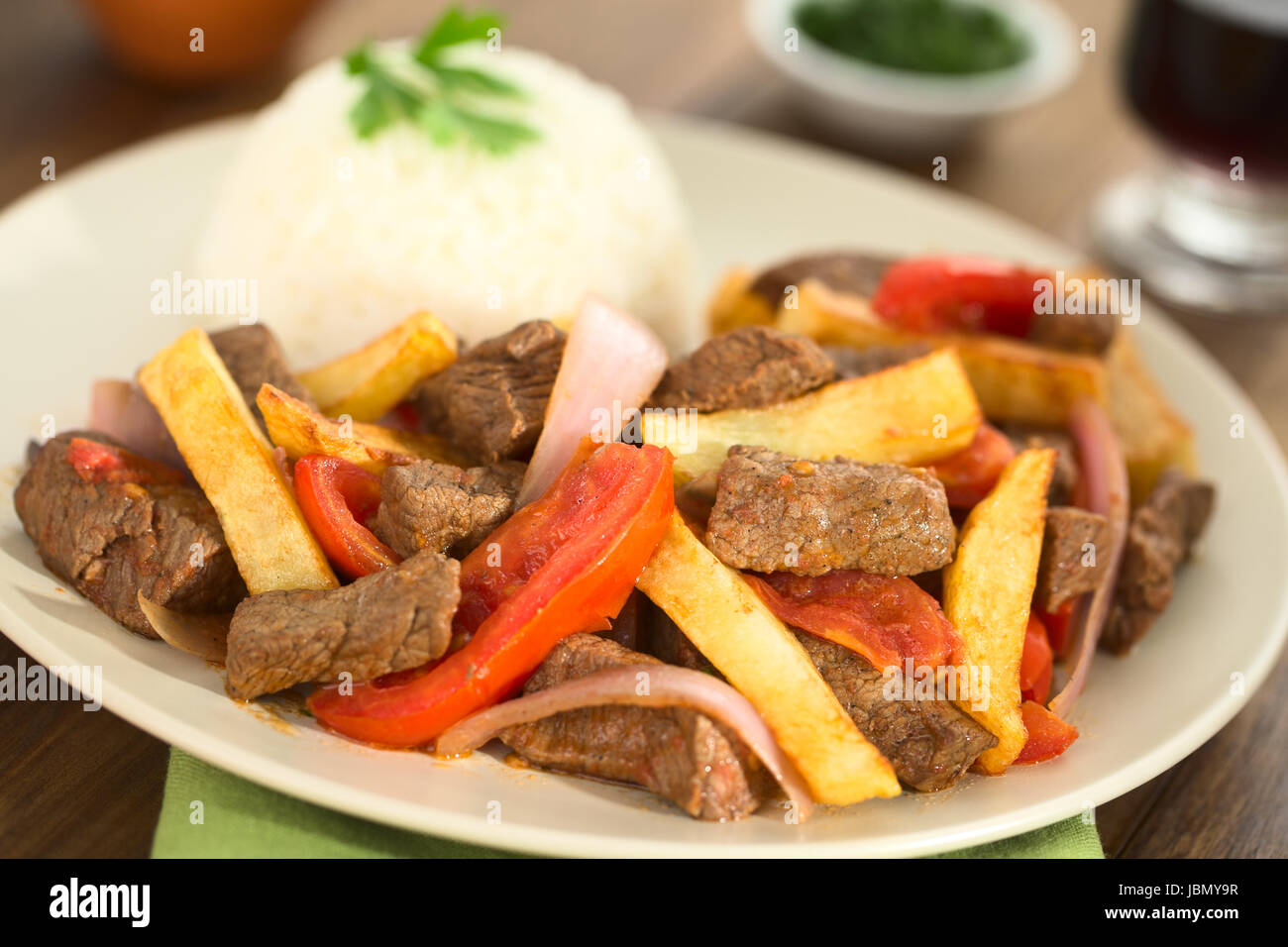 Peruvian dish called Lomo Saltado made of beef, tomato, red onion and French fries, served with rice (Selective Focus, Focus one third into the dish) Stock Photo