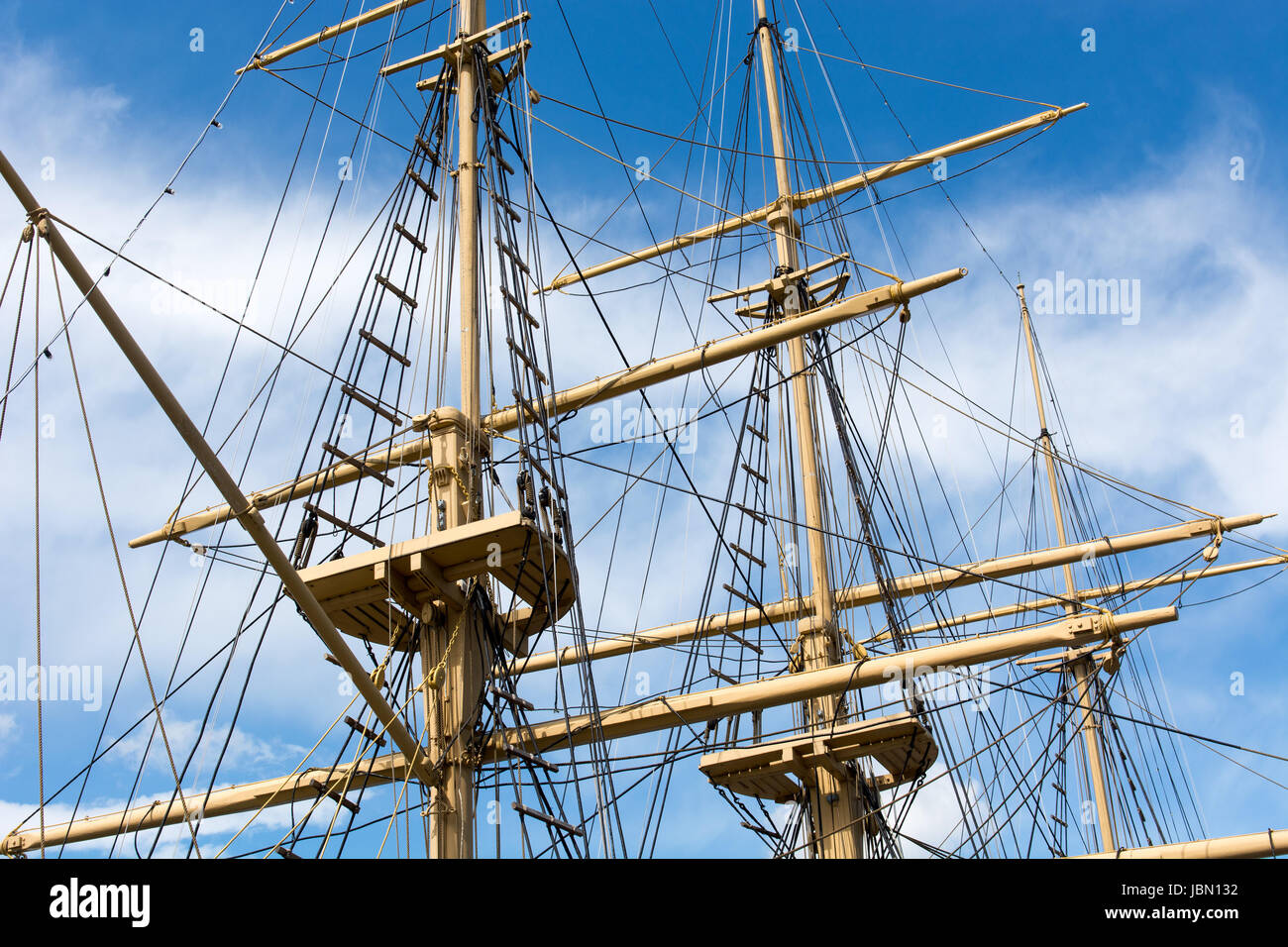 Masts and rigging of a big old sailing ship in front of a blue sky ...