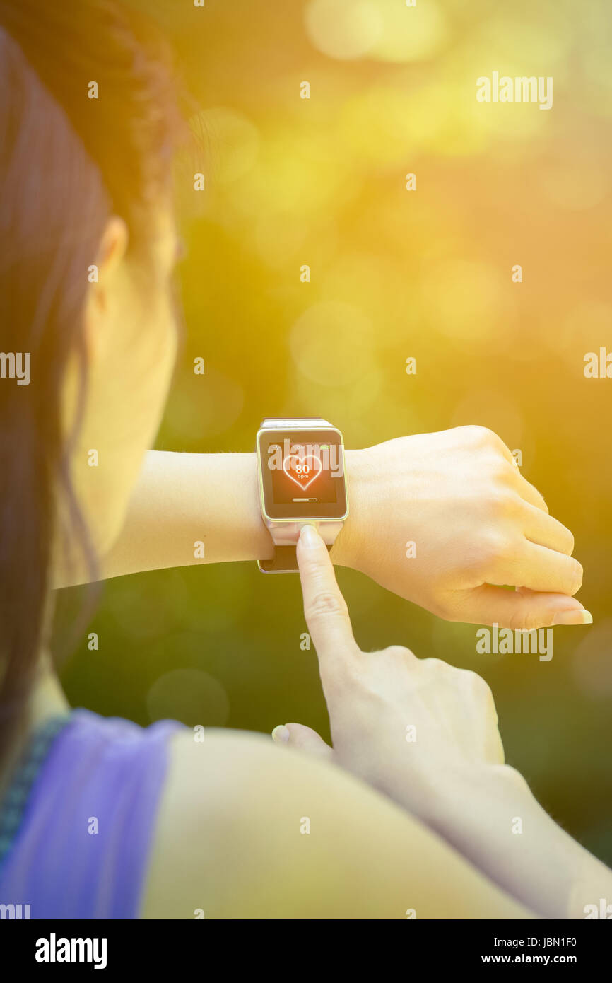 Young female athlete looking at heart rate app and checking beats per