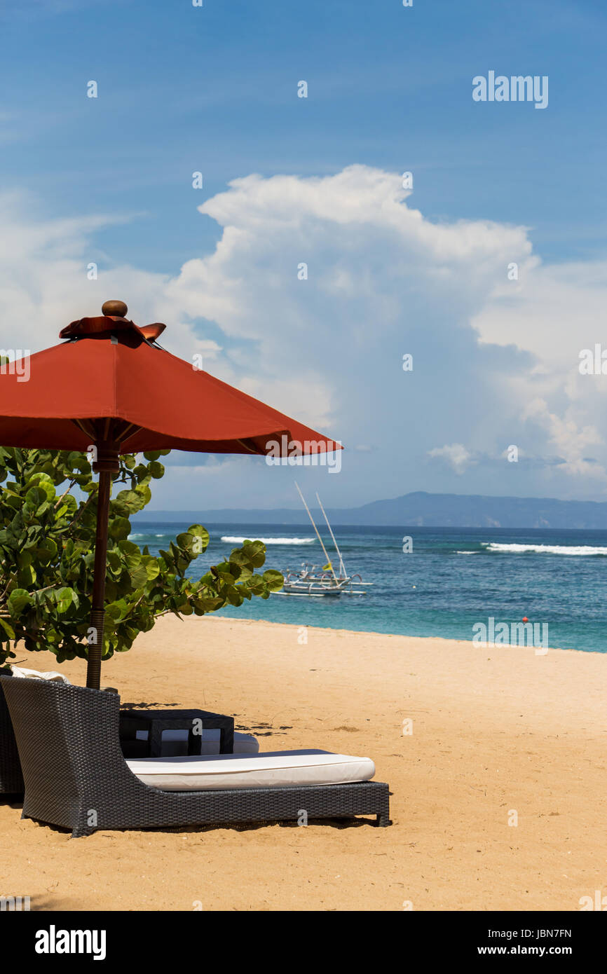 Tropischer Strand mit Sonnenliege und Sonnenschirmen mit weißem Sand in der Karibik Stock Photo