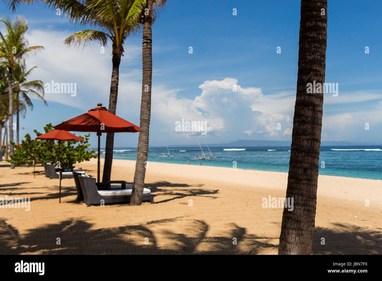 Tropischer Strand mit Sonnenliege und Sonnenschirmen mit weißem Sand in der Karibik Stock Photo