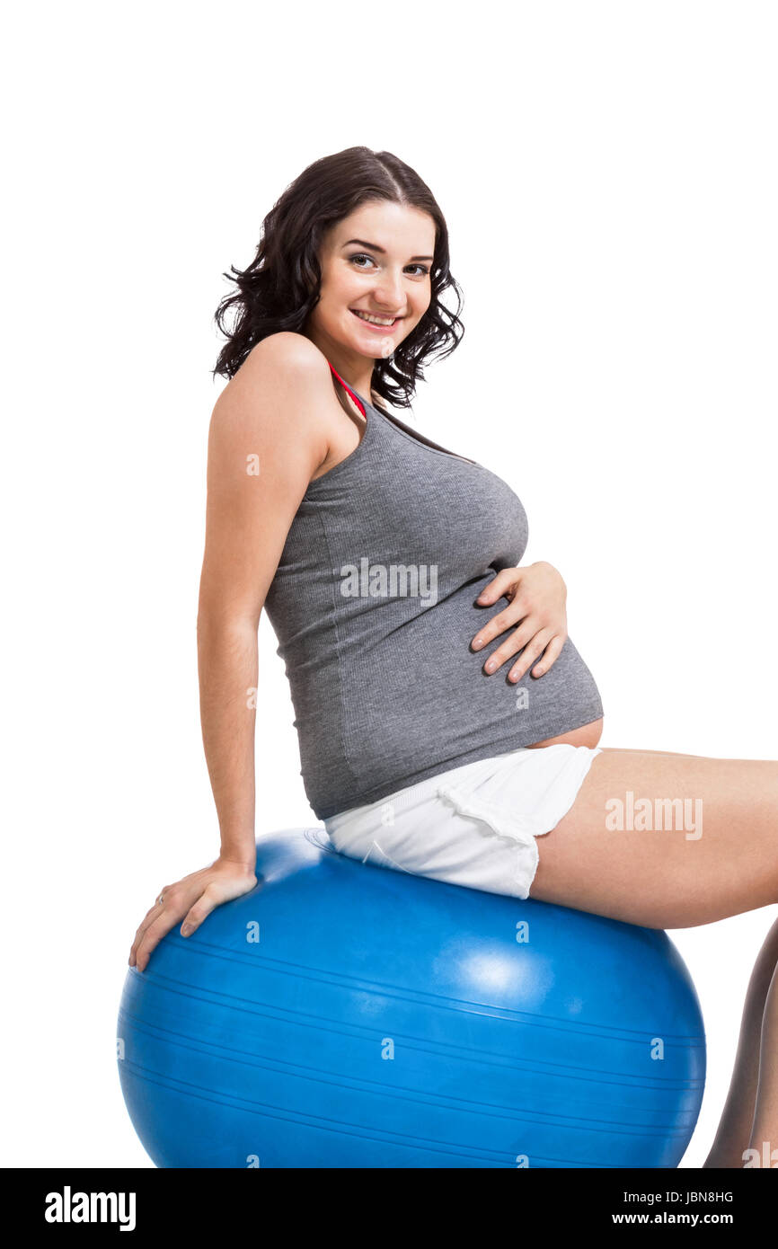 Attraktive schwangere Frau auf einem blauen Gymnastikball zur Gebrurtsvorbereitung Stock Photo