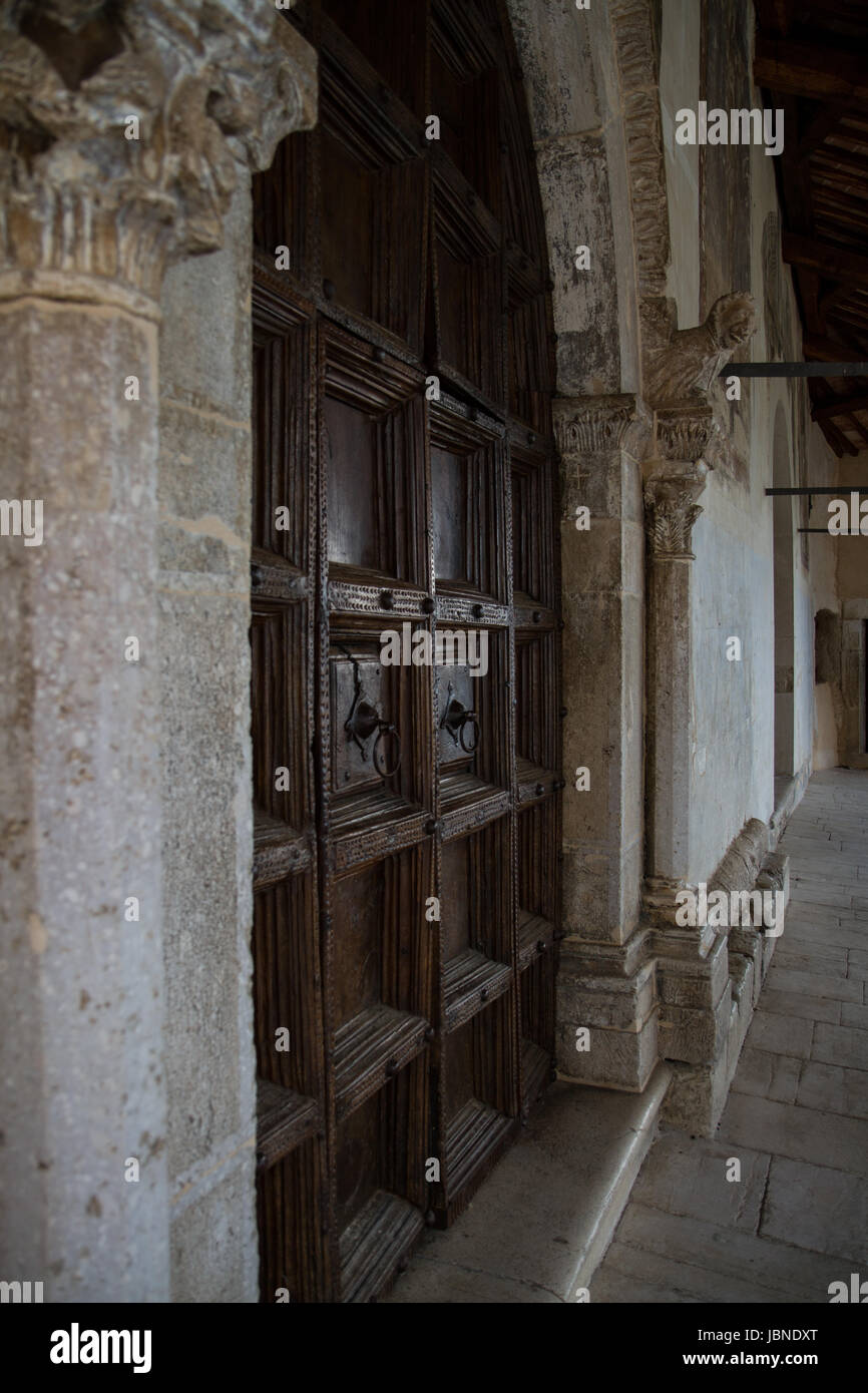 The Church- An ancient church boasts hand carved ornate stone columns and hand carved wood doors. Stock Photo