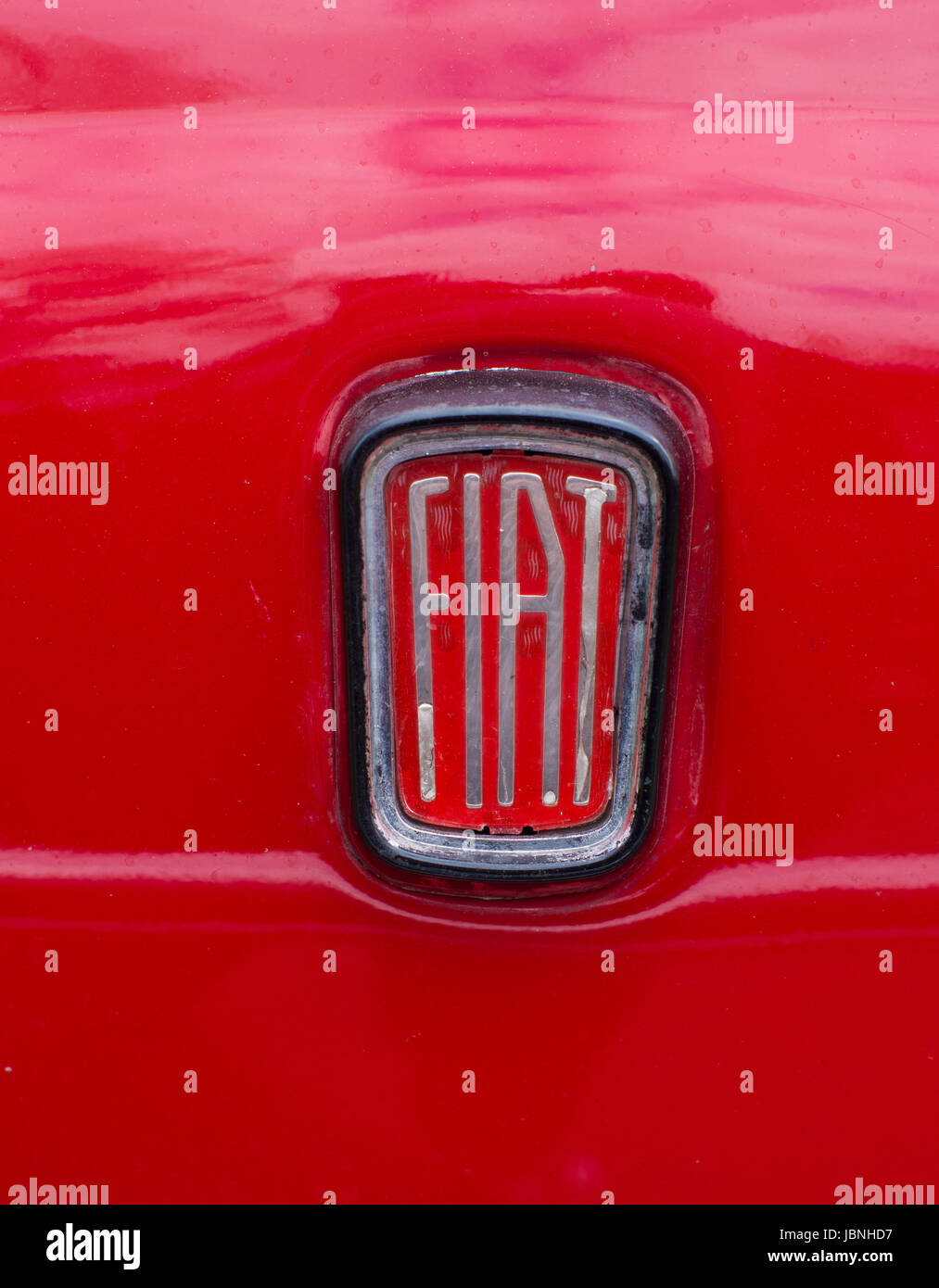 close-up of an old fiat logo on a red car. In honor of the 100th anniversary in 1999, the logo was modernized. Stock Photo