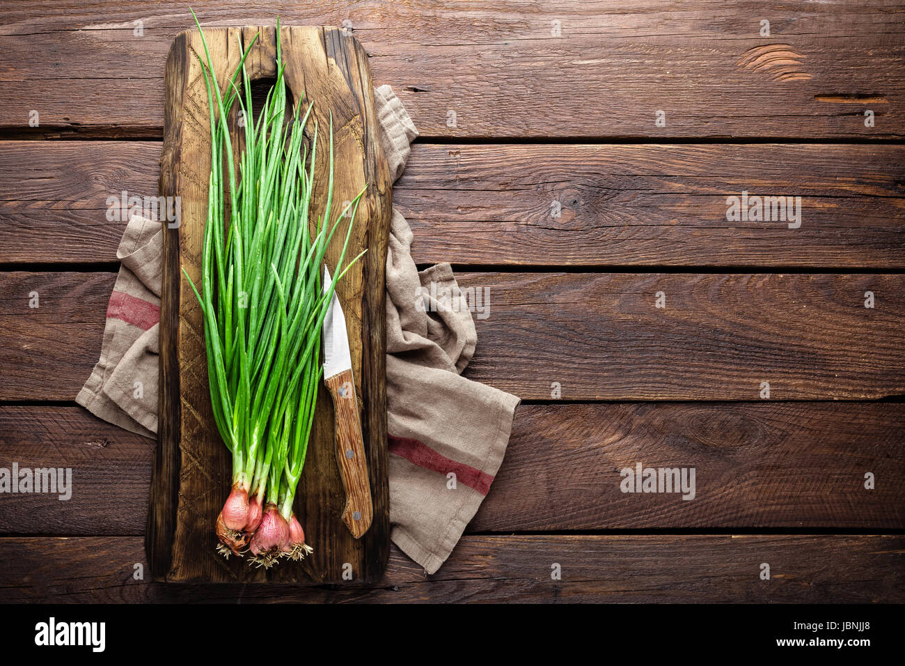 Green onion or scallion on wooden board, fresh spring chives Stock