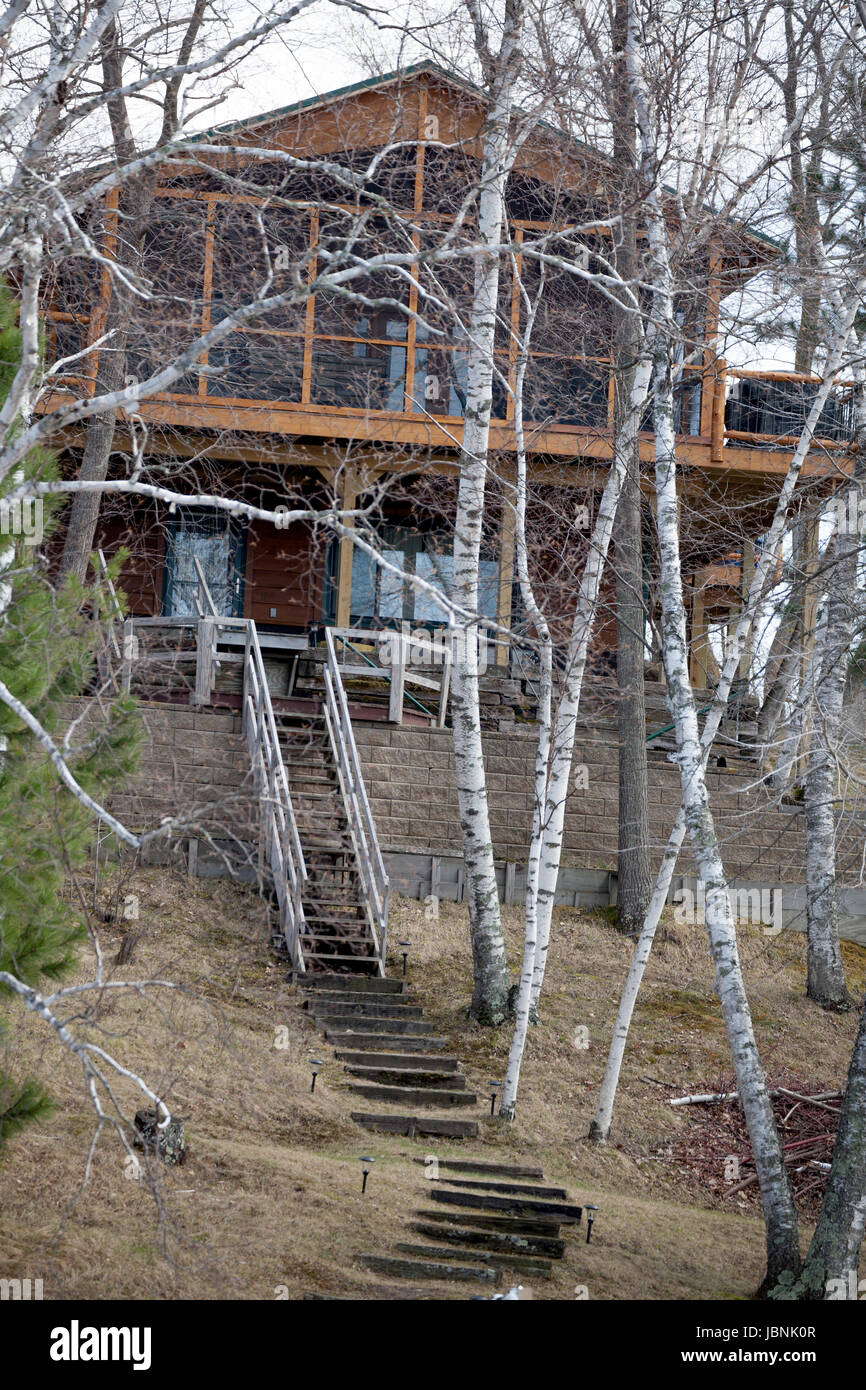 Modern cabin on the lake with birch trees in front on the bank. Nisswa