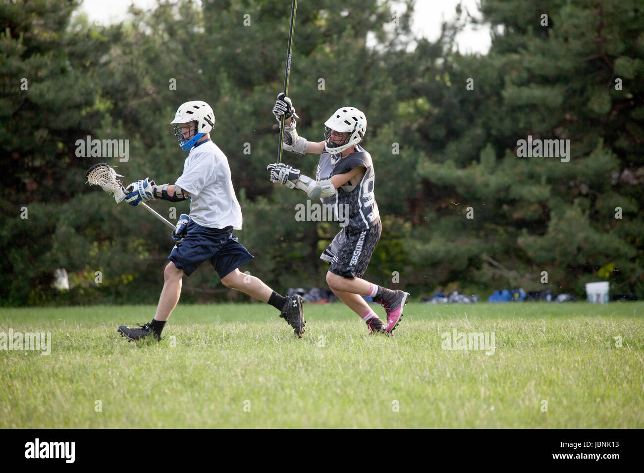 High school Lacrosse players running with ball in stick pocket. St Paul
