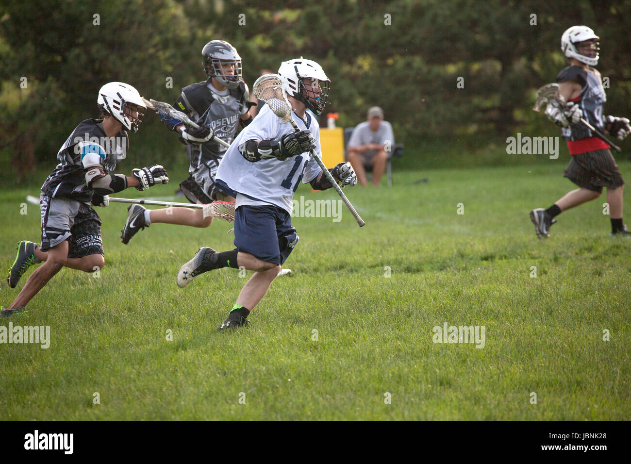 Lacrosse high school player running with ball in stick pocket being