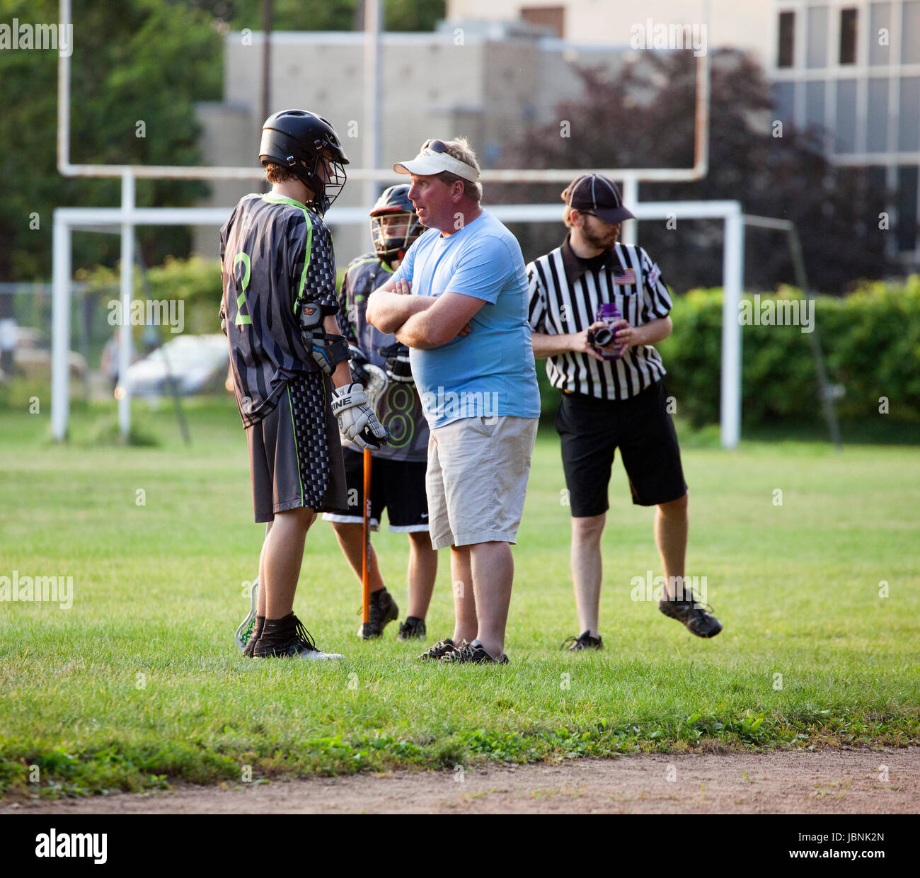 Intense conversation between coach and high school lacrosse player