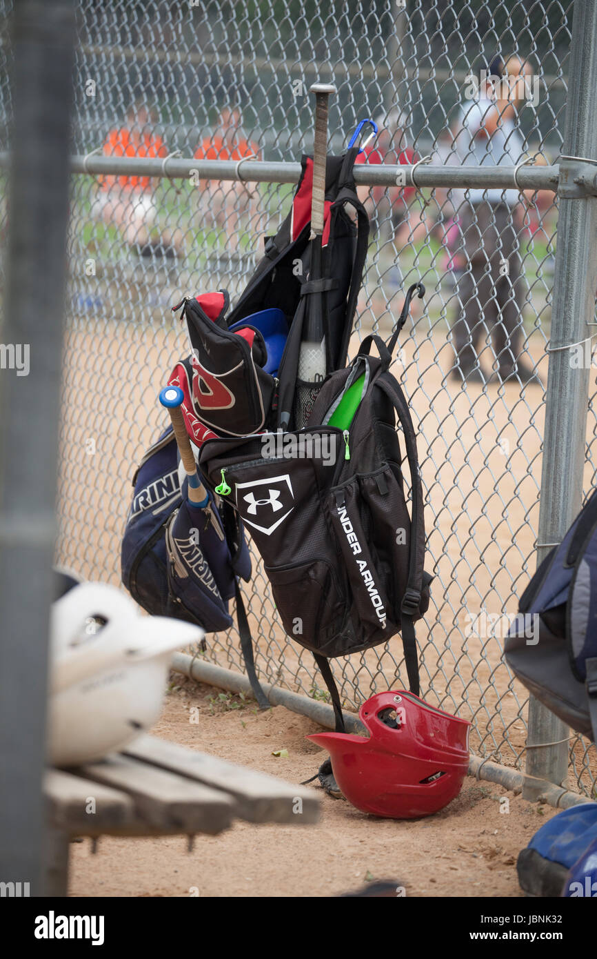 Baseball equipment hanging on the fence in dugout during game. St Paul