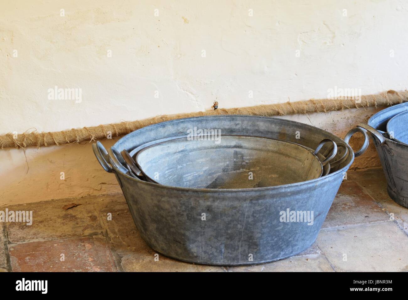 cast iron washing tubs on floor Stock Photo Alamy