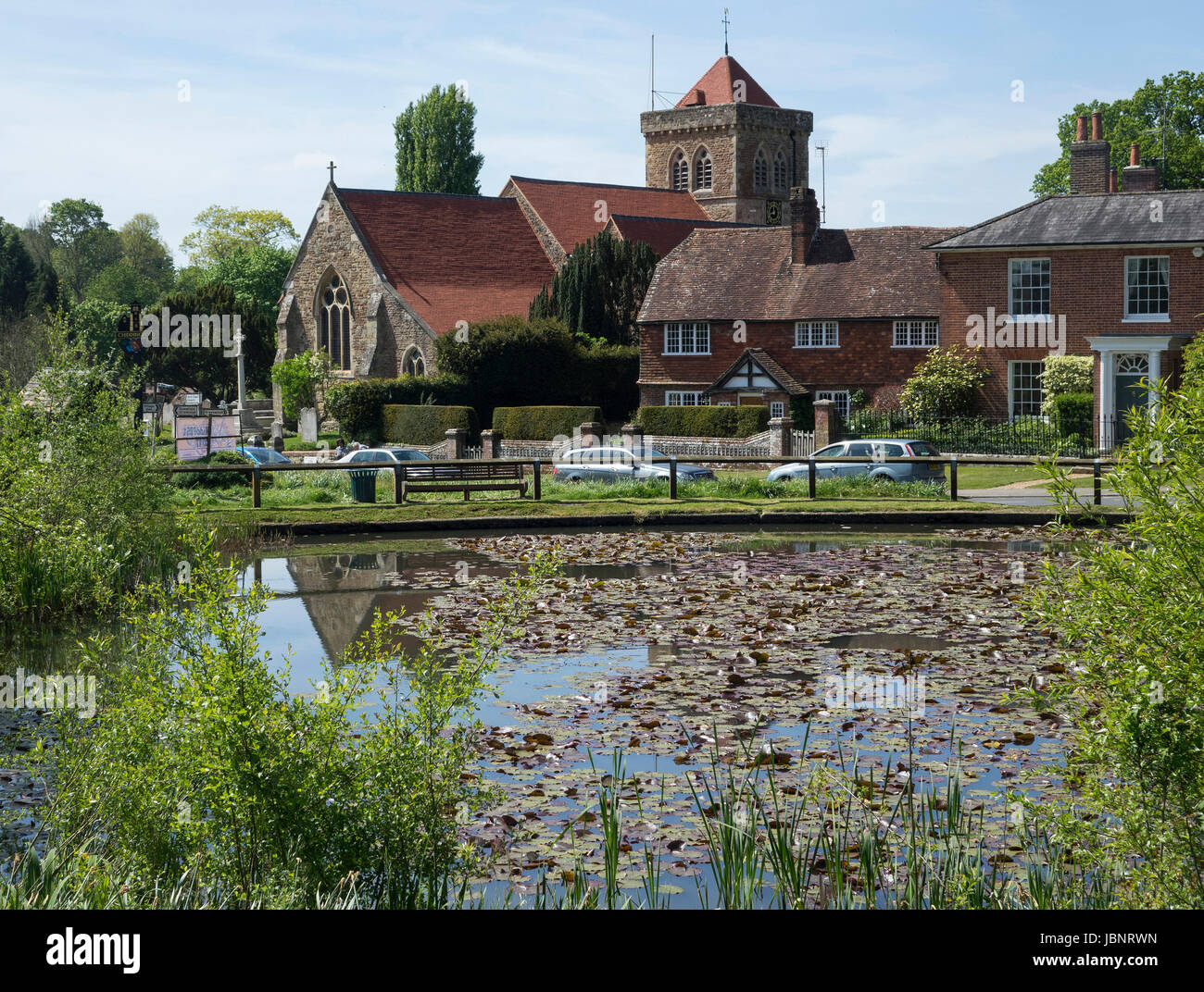 England, Surrey, Chiddingfold, StMary's church & pond Stock Photo