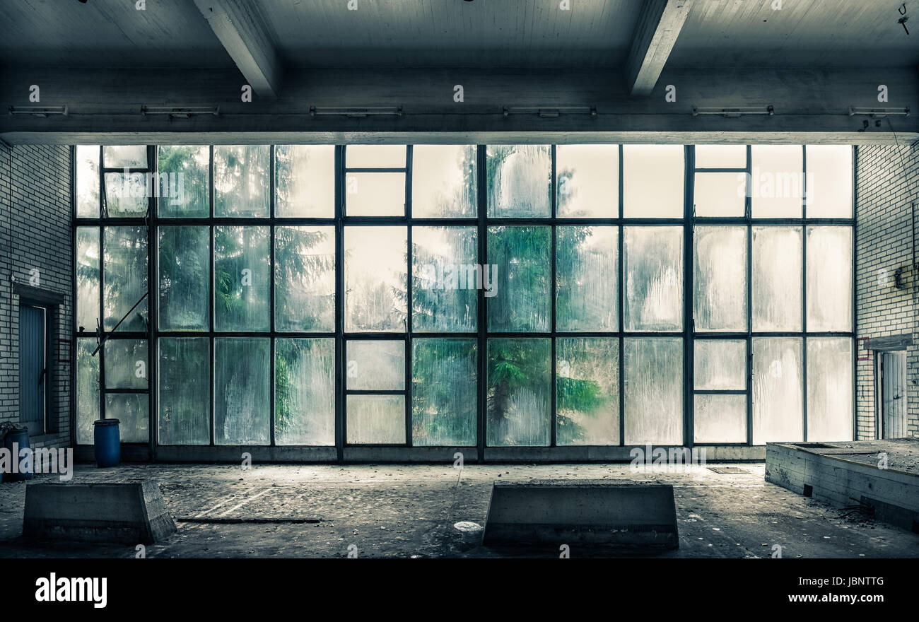 The view from an old, abandoned factory on the inside with nice window light Stock Photo