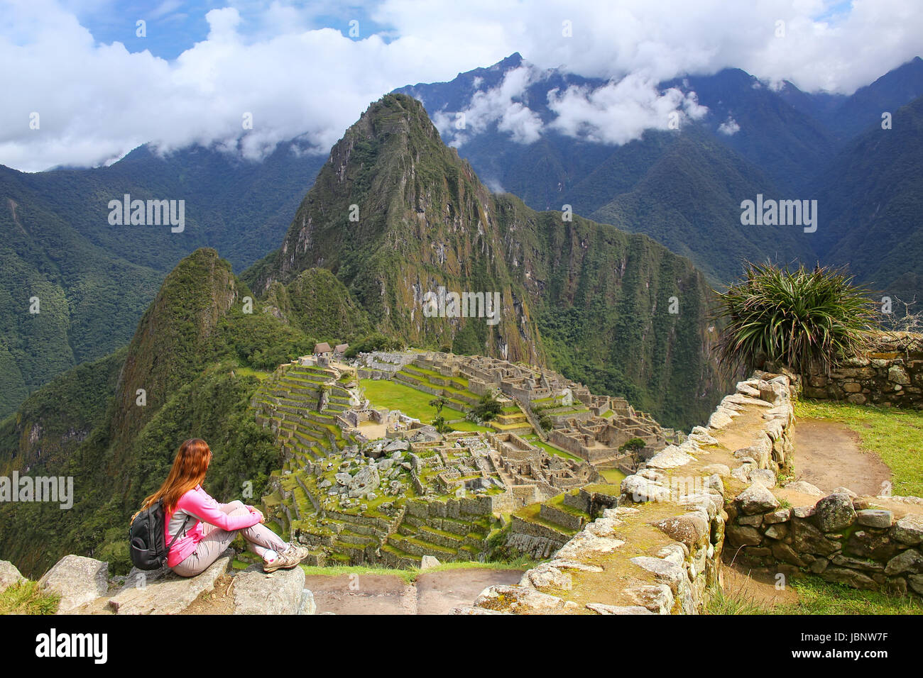 Woman enjoying the view of Machu Picchu citadel in Peru. In 2007 Machu Picchu was voted one of the New Seven Wonders of the World. Stock Photo