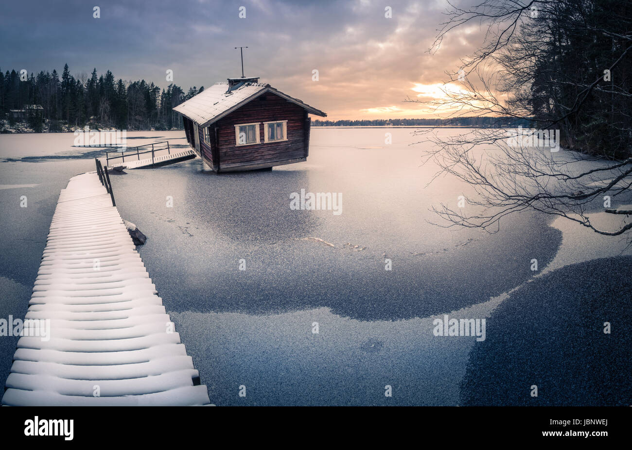 Abandoned cottage with sunset at winter evening in Finland Stock Photo
