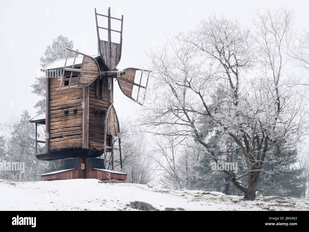 Winter landscape with old and abandoned windmill at daytime in Finland Stock Photo