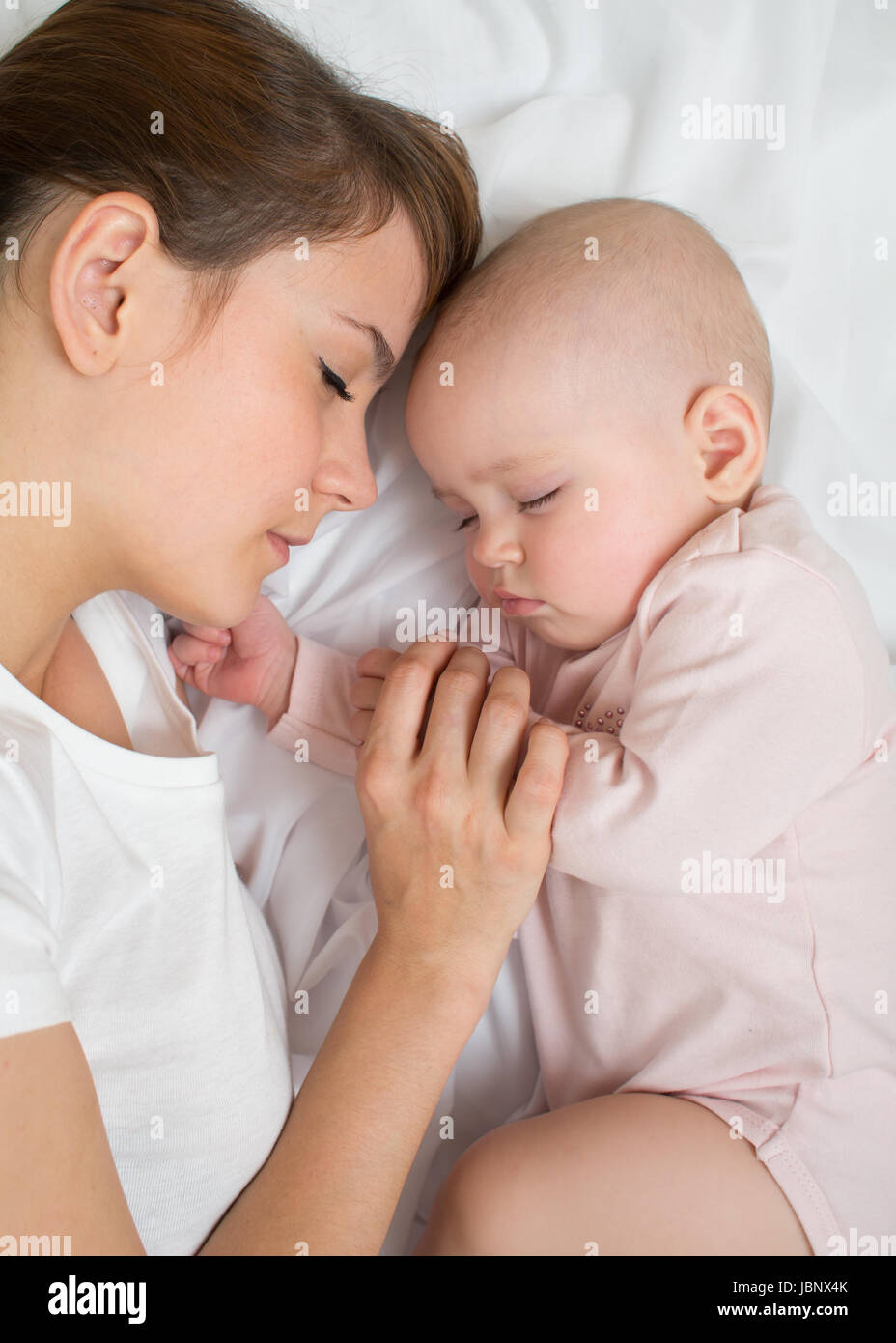 Mother and baby sleep in bed together Stock Photo Alamy