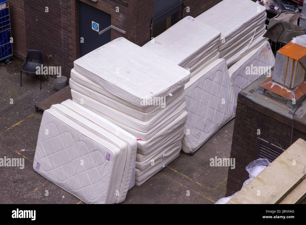 Stack of old dirty mattresses ready to be junked during a hotel