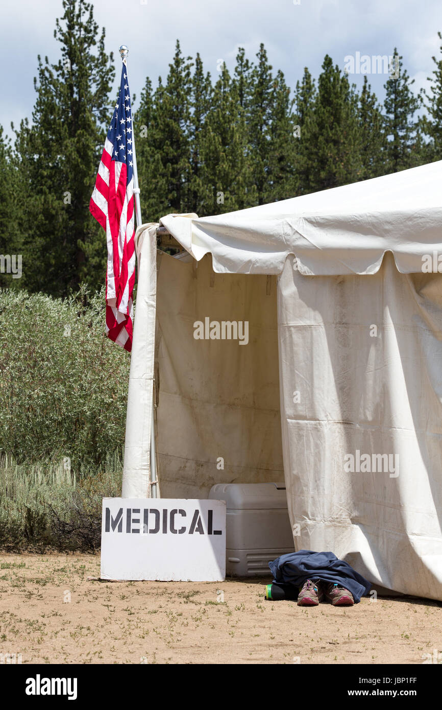 Medical tent entrance with a hand-made medical sign and an American Flag.  Runners aid station, as indicated by the shoes outside of the entrance. Stock Photo