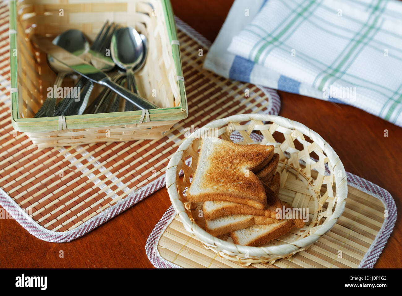 Croutons in a basket and cutlery on a table Stock Photo