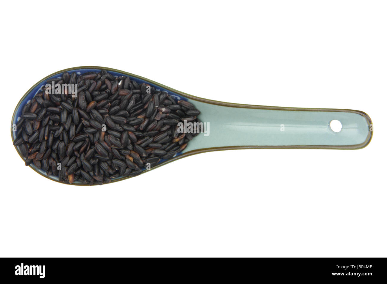 close up of black rice with china scoop isolated on white background ...