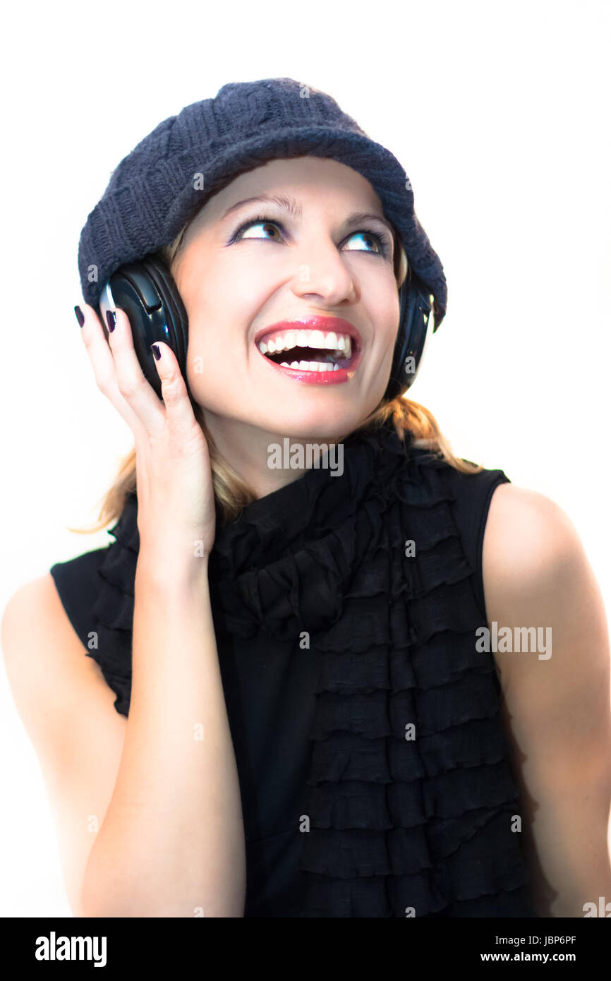 Blonde caucasian girl listening to the music with a pair of headphones ...