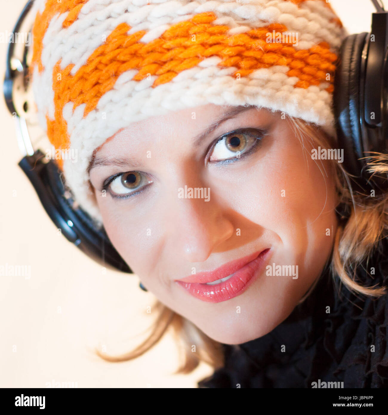 Blonde caucasian girl listening to the music with a pair of headphones ...