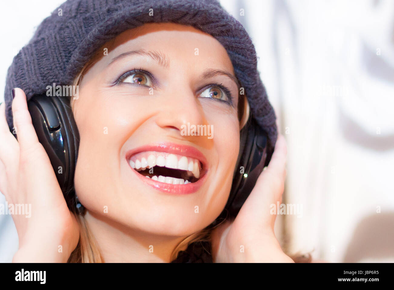 Blonde caucasian girl listening to the music with a pair of headphones ...