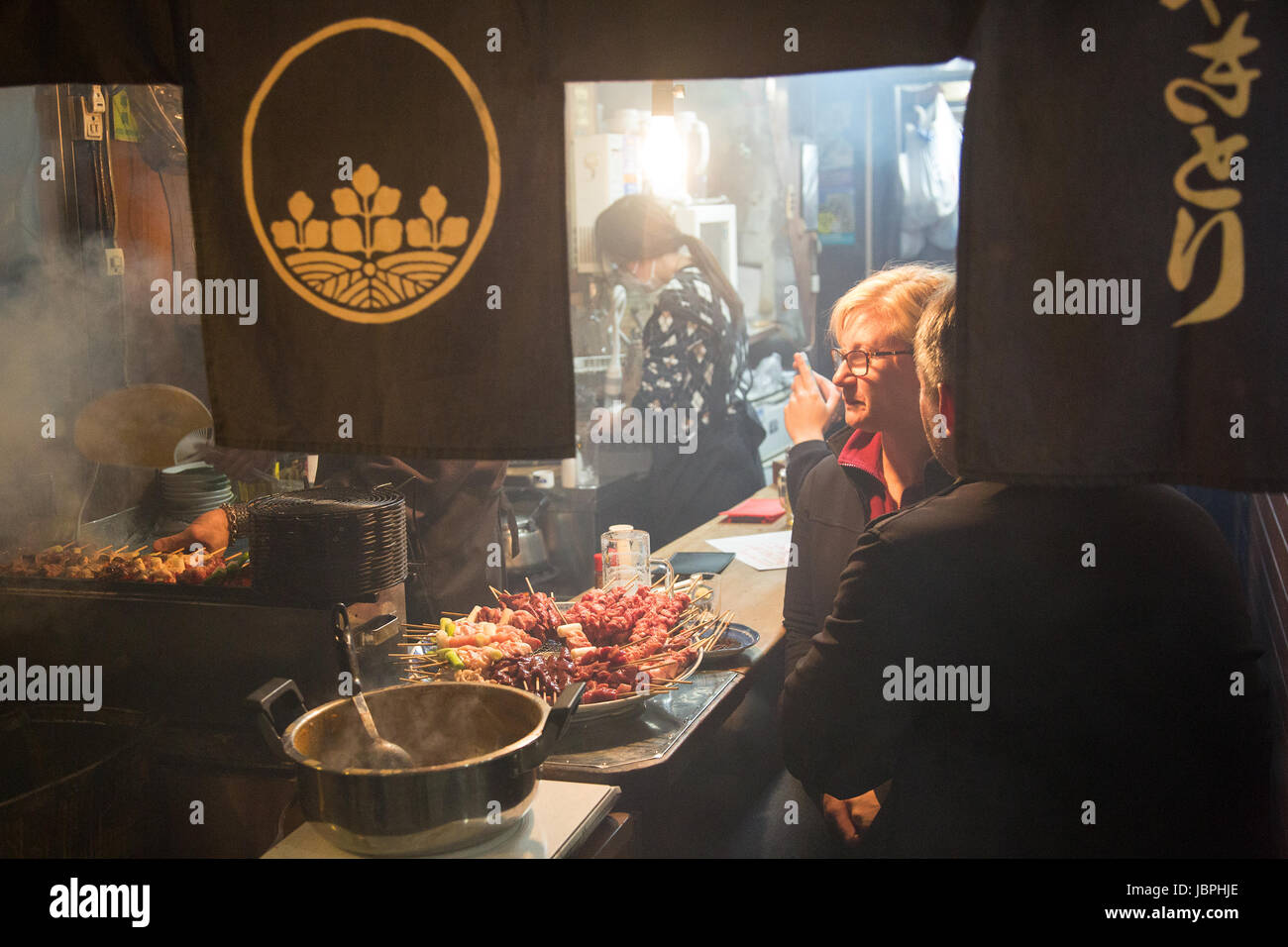 Patrons at an izakaya in Yakitori Alley, Tokyo, Japan Stock Photo