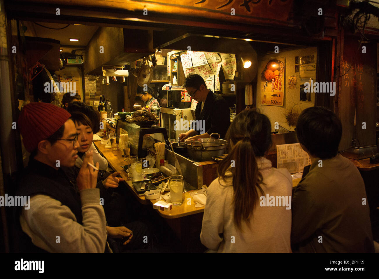 Patrons at an izakaya in Yakitori Alley, Tokyo, Japan Stock Photo